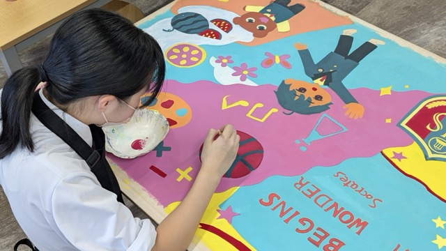 A student at Kumamoto International School working on her poster project